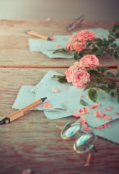 Rosas rosadas con gafas sobre mesa de madera — Foto de Stock