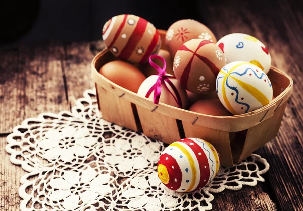 Colorful Easter eggs in a little basket. — Stock Photo, Image