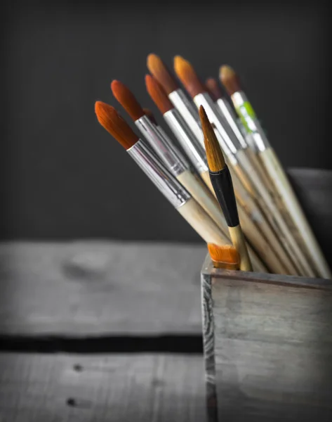 Paint brushes in a wooden jar — Stock Photo, Image