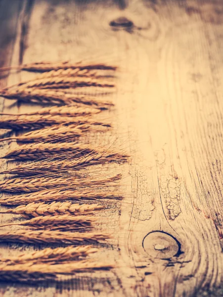 Spikelets of wheat on old wooden table — Stock Photo, Image