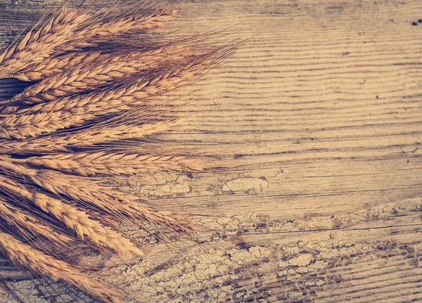 Espiguillas de trigo sobre una vieja mesa de madera — Foto de Stock