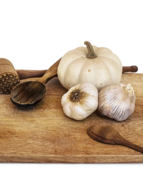 Garlic, pumpkin, wooden spoons and kitchen hammer — Stock Photo, Image