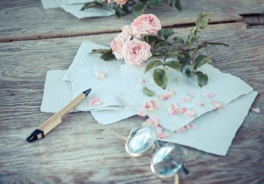 Ahşap masa gözlüklerle pembe güller