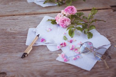 Ahşap masa gözlüklerle pembe güller