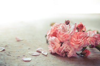 ahşap masa üstünde pembe güller