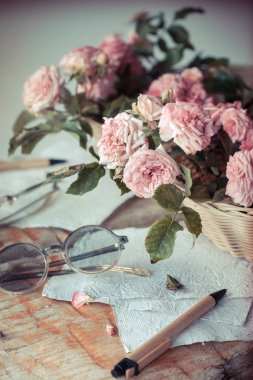 Ahşap masa gözlüklerle pembe güller