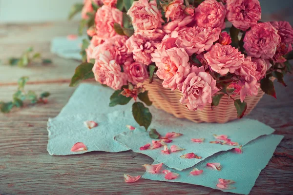 나무 테이블에 서류와 함께 핑크 장미 — 스톡 사진