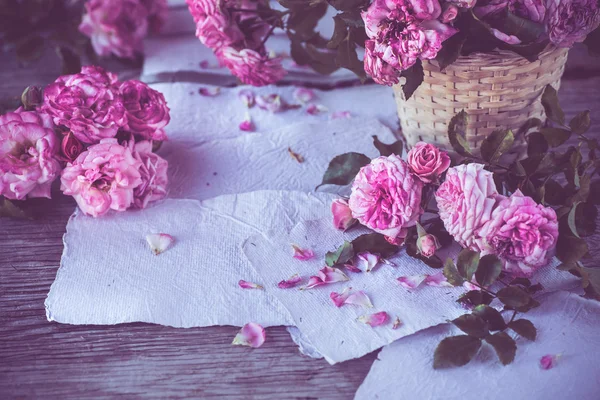 Ροζ τριαντάφυλλα με έγγραφα σχετικά με ξύλινο τραπέζι — Φωτογραφία Αρχείου