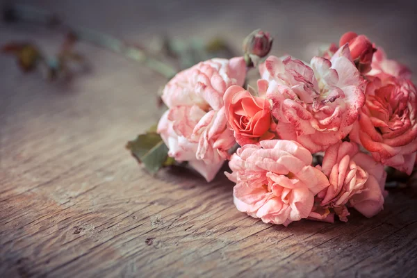 Розовые розы на деревянном столе — стоковое фото