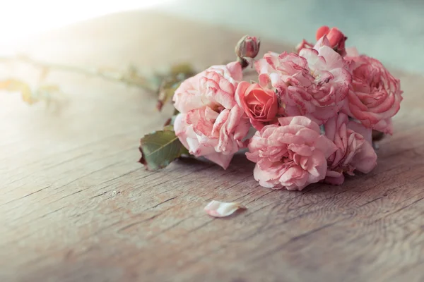 Rosas cor-de-rosa na mesa de madeira — Fotografia de Stock