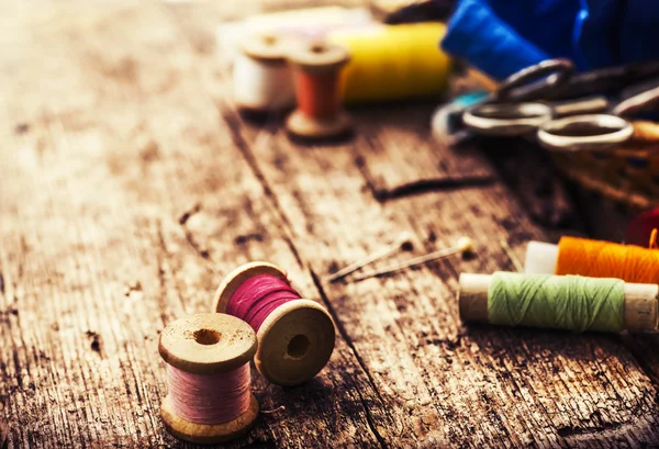 Klossen, naalden, schaar op houten tafel — Stockfoto