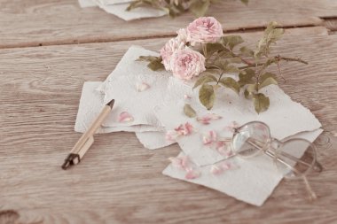 Ahşap masa gözlüklerle pembe güller