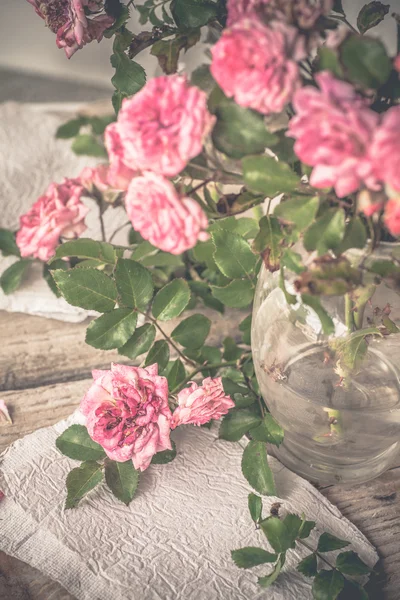 Růžové růže s papíry na dřevěný stůl — Stock fotografie
