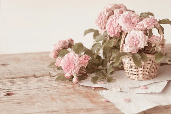 Rosas rosadas con papeles sobre mesa de madera — Foto de Stock