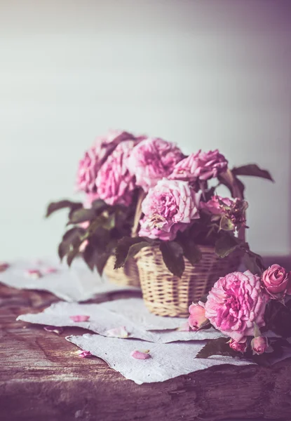 Rosas rosadas con papeles sobre mesa de madera —  Fotos de Stock