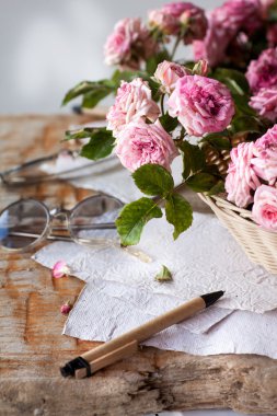 Ahşap masa gözlüklerle pembe güller