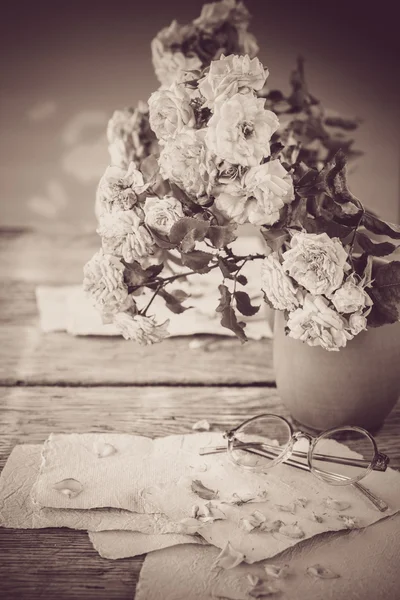 Rosas con gafas sobre mesa de madera —  Fotos de Stock