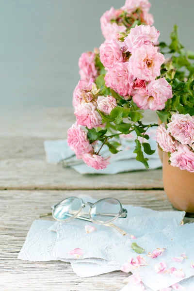 Trandafiri roz cu ochelari pe masa de lemn — Fotografie, imagine de stoc