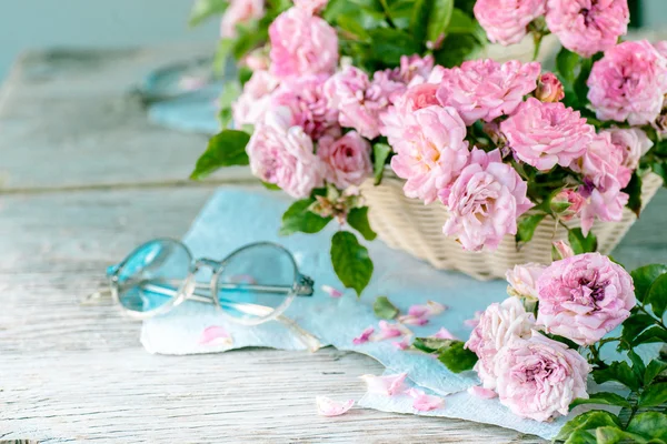 Ahşap masa gözlüklerle pembe güller