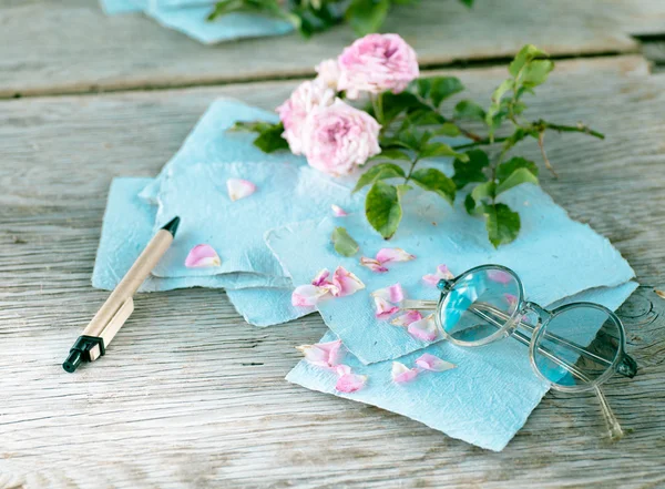 Ahşap masa gözlüklerle pembe güller