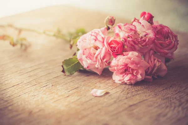 Rosas cor-de-rosa na mesa de madeira — Fotografia de Stock