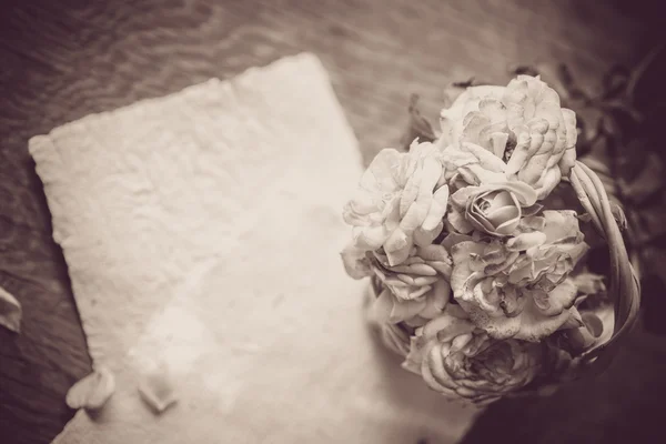 Roses avec papiers sur table en bois — Photo