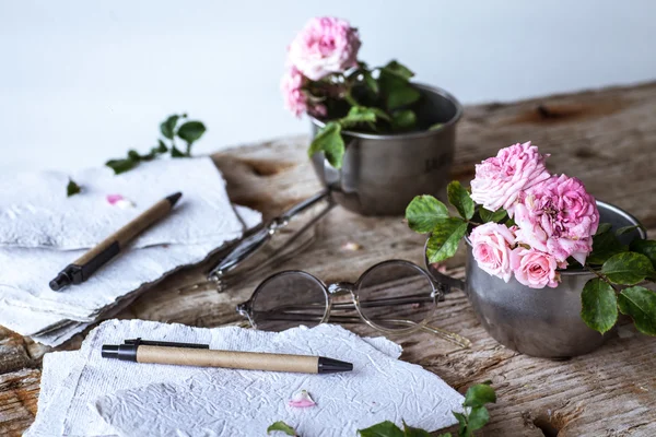 Rosas rosadas con gafas sobre mesa de madera — Foto de Stock