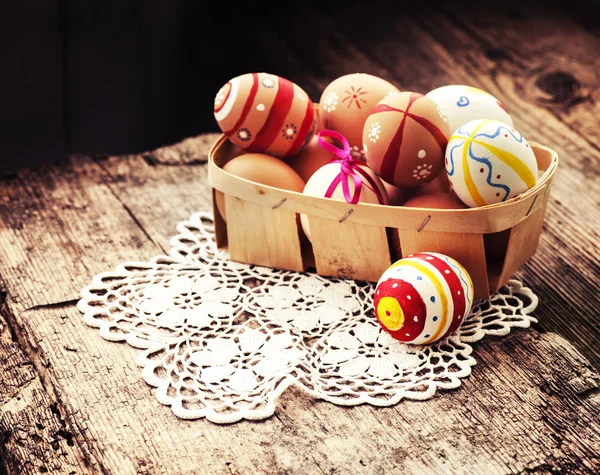 Colorful Easter eggs in a little basket. — Stock Photo, Image