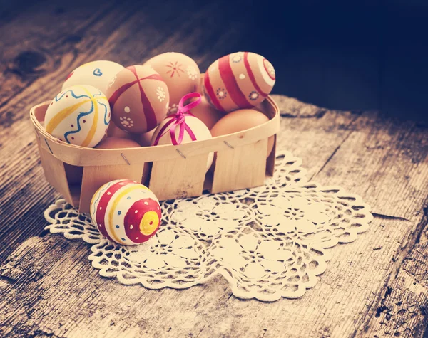 Colorful Easter eggs in a little basket. — Stock Photo, Image