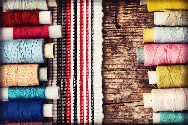 Бобины с нитями и полосатой тканью — стоковое фото