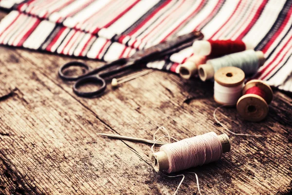 Scissors, fabric and bobbins with threads — Stock Photo, Image