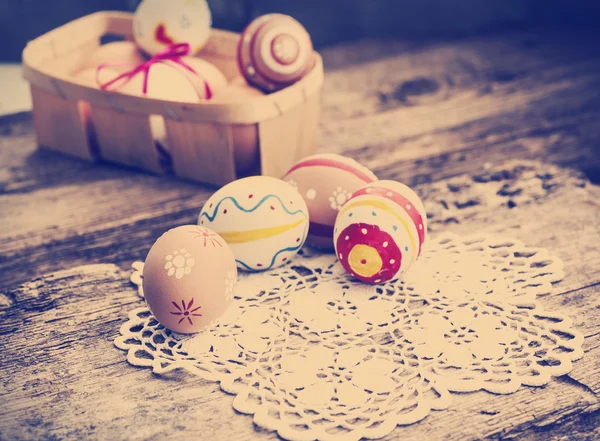 Des œufs de Pâques colorés dans un petit panier . — Photo