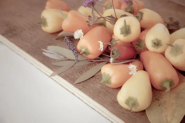 Paprika's op een houten bord, Herfstbladeren — Stockfoto