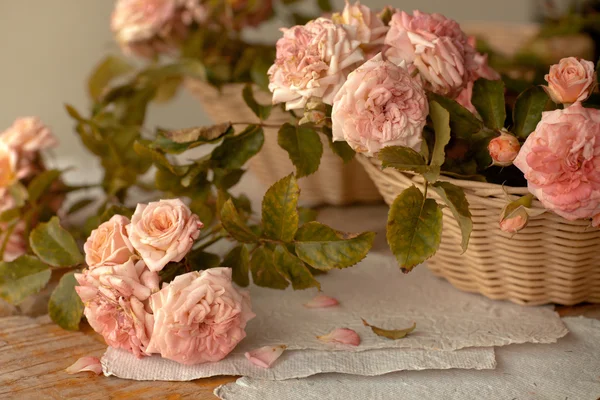 Roze rozen met papieren op houten tafel — Stockfoto
