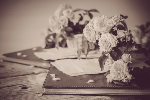 Rosas com papéis na mesa de madeira — Fotografia de Stock