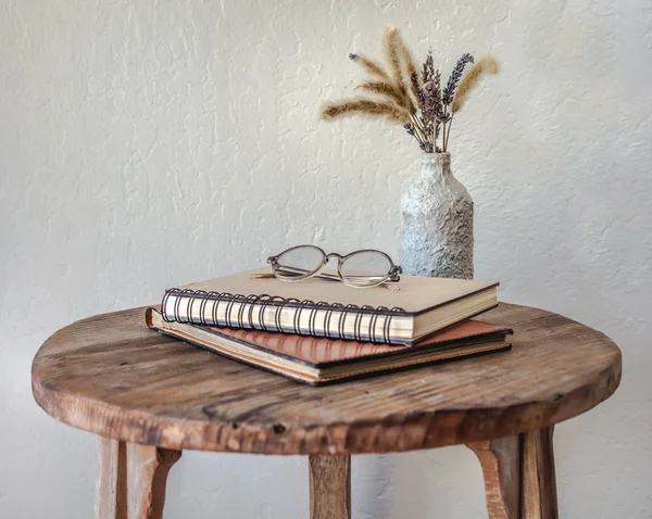 Bunch of books, vase with flowers and glasses — Stock Photo, Image