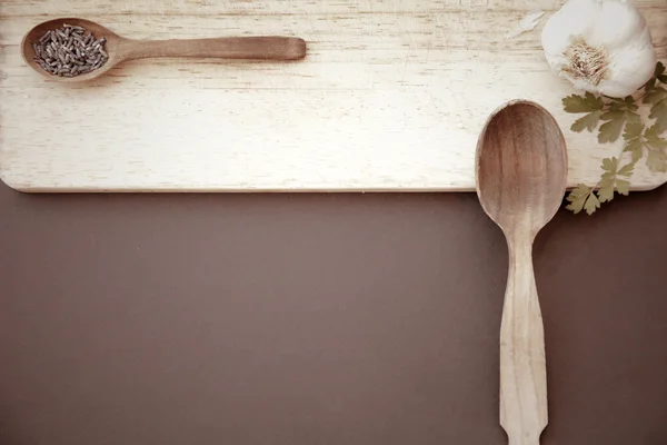 Close-up of garlic and wooden spoons — Stock Photo, Image