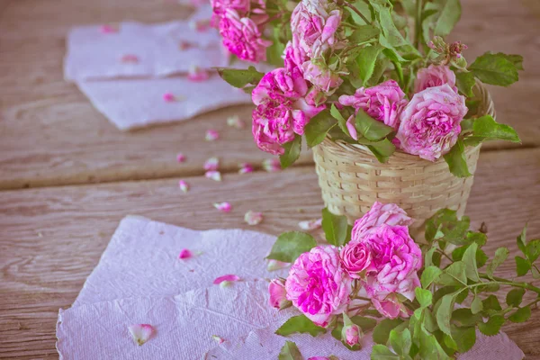 Rosa Rosen mit Papieren auf Holztisch — Stockfoto