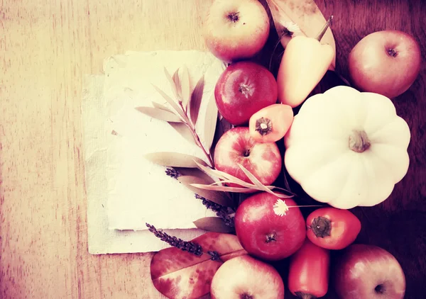 Fondo con pequeñas manzanas, calabaza, libros blancos y hojas — Foto de Stock