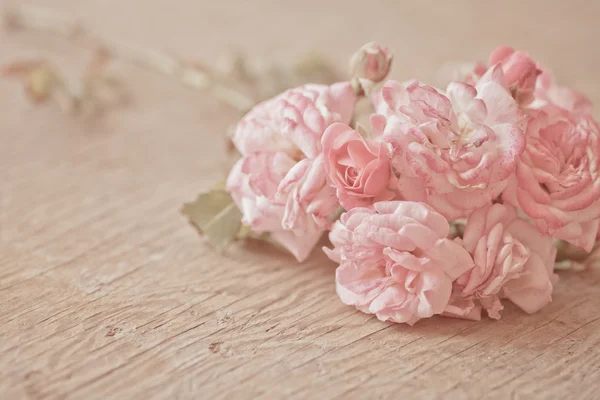 Rosas cor-de-rosa na mesa de madeira — Fotografia de Stock