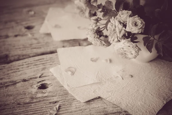 Розы и белые бумаги — стоковое фото