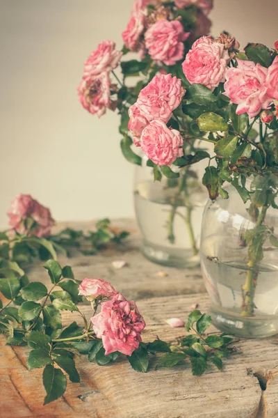 Rosas cor-de-rosa na mesa de madeira — Fotografia de Stock