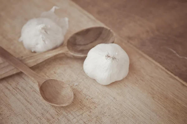 Garlic and wooden spoons — Stock Photo, Image