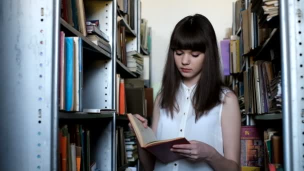 Красивая девушка в библиотеке — стоковое видео