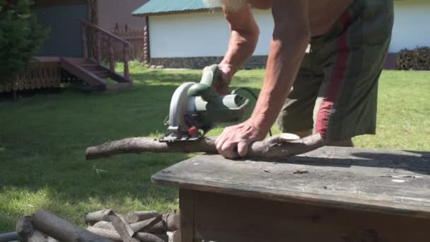Den gamle mannen sågning av trä — Stockvideo