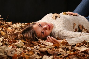 Sonbahar yaprakları kaplı güzel kız