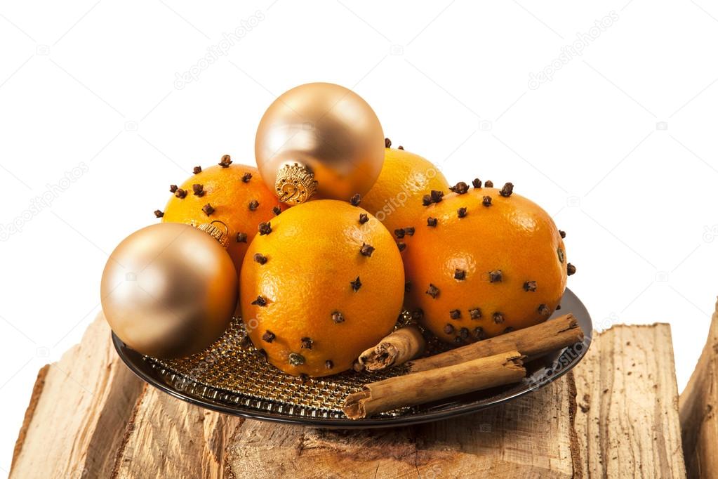 Christmas orange and baubles with cinnamon sticks on firewood