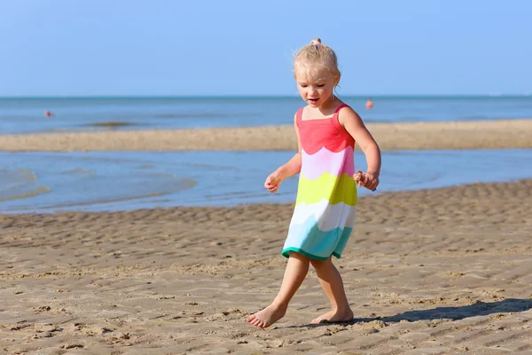 Lycklig liten flicka njuter dag på stranden — Stockfoto