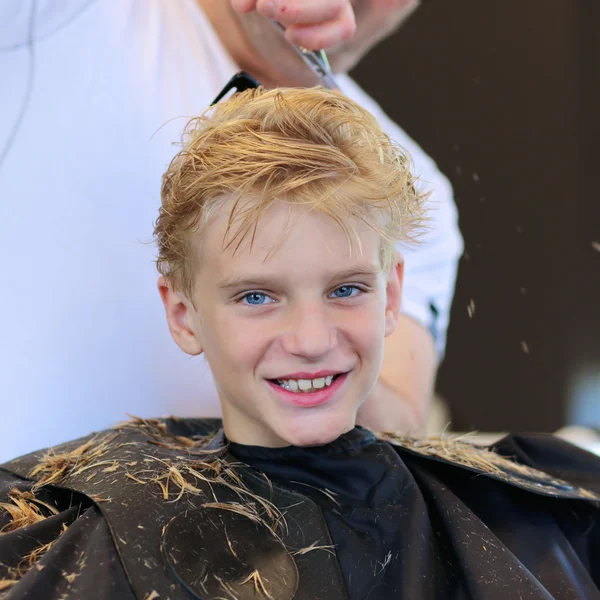 Nastoletni chłopiec mający fryzura — Zdjęcie stockowe
