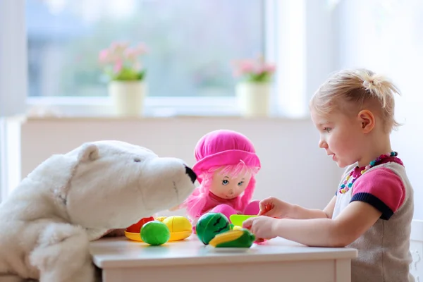 Batole dívka si hraje s hračkami uvnitř — Stock fotografie